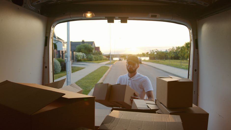 Crew member loading boxes into the truck on a residential street